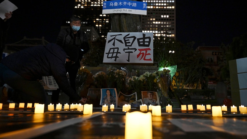 旧金山花园角广场上摆放着蜡烛和上海乌鲁木齐路的路牌