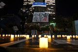 旧金山花园角广场上摆放着蜡烛和上海乌鲁木齐路的路牌