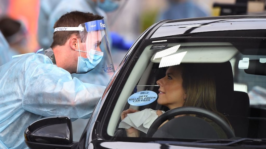 An ADF member takes a COVID-19 swab sample at a drive through.