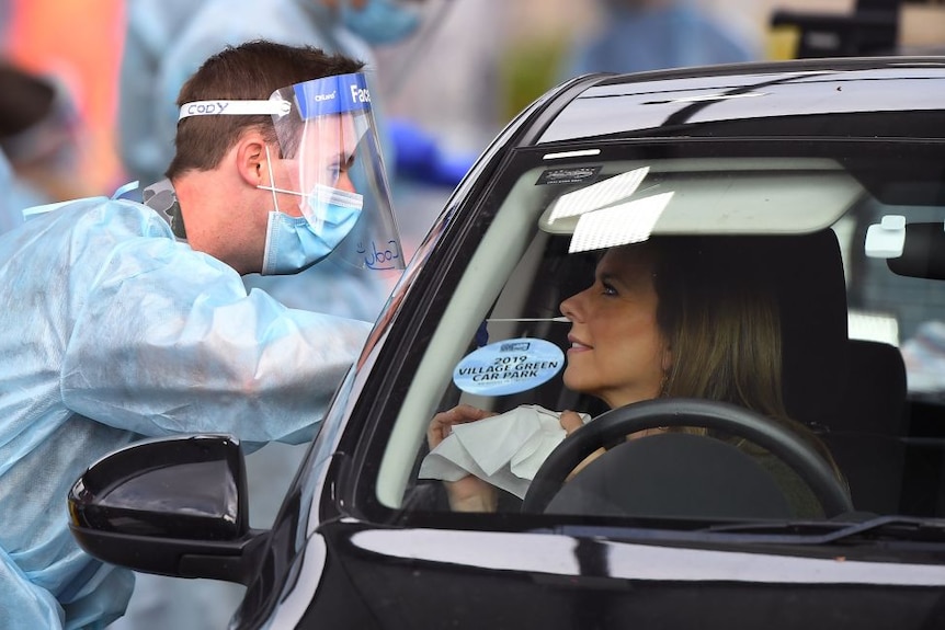 An ADF member takes a COVID-19 swab sample at a drive through.