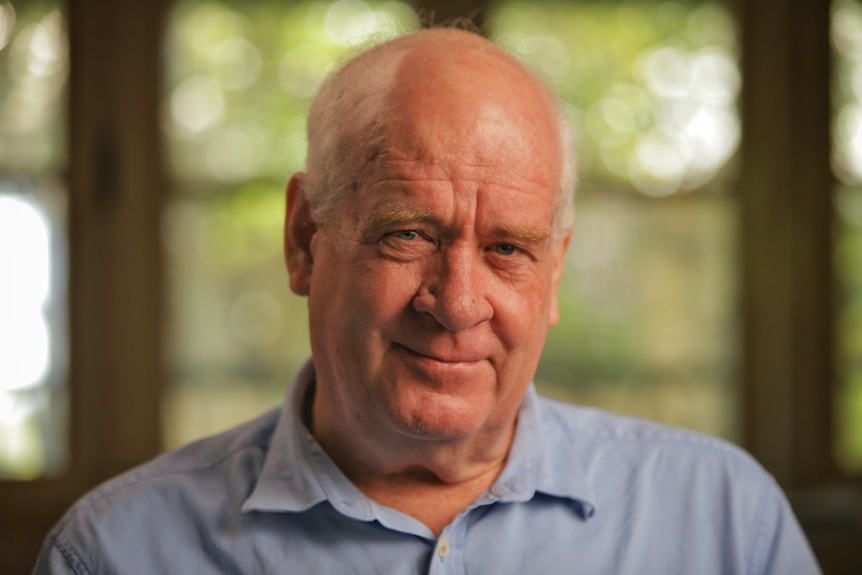 A man wearing a blue collared shirt.