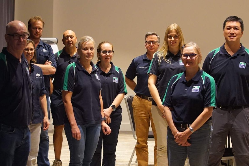 A group of Australian DFAT workers in blue polo shirts