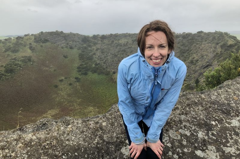A woman in a blue rain jacket at the top of volcanic crater Mount Schank, near Mount Gambier