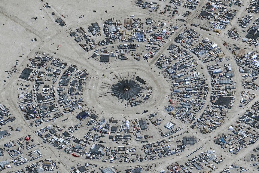 Bird's eyeview of a circular, sprawling city in the desert.