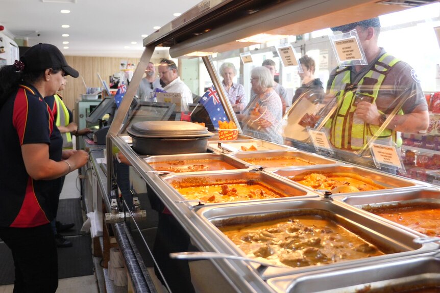 A line of hungry customers in front of a bain-marie.
