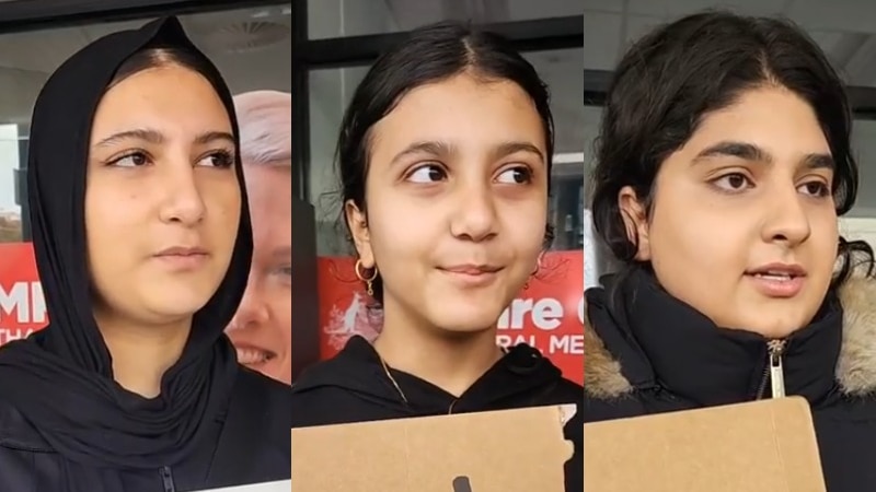 Three young women with an Iranian background speak to the camera at an migration law rally. 
