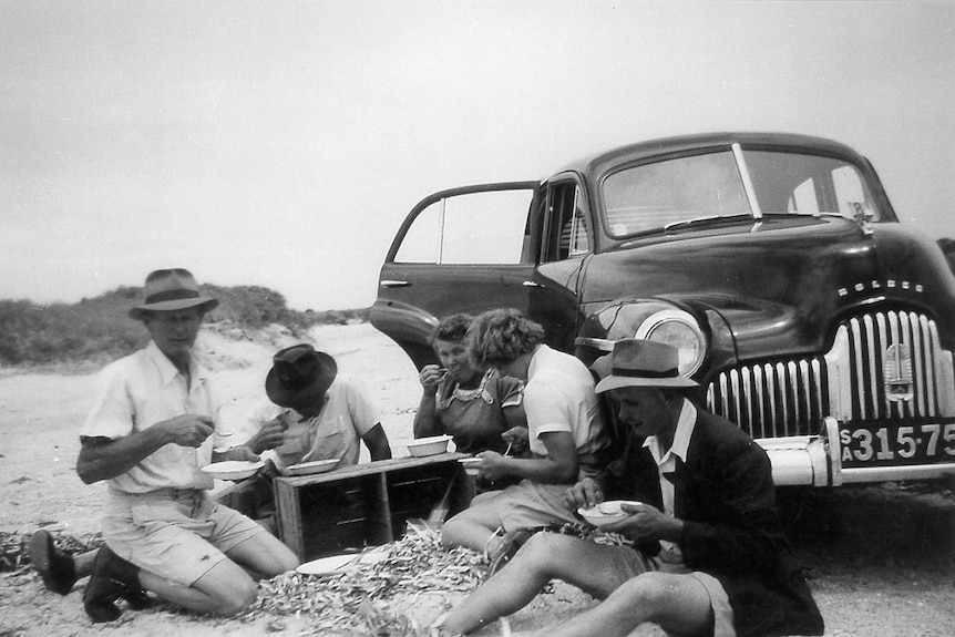 A family has a picnic next to its Holden