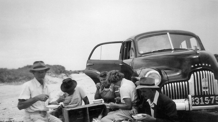 A family has a picnic next to its Holden