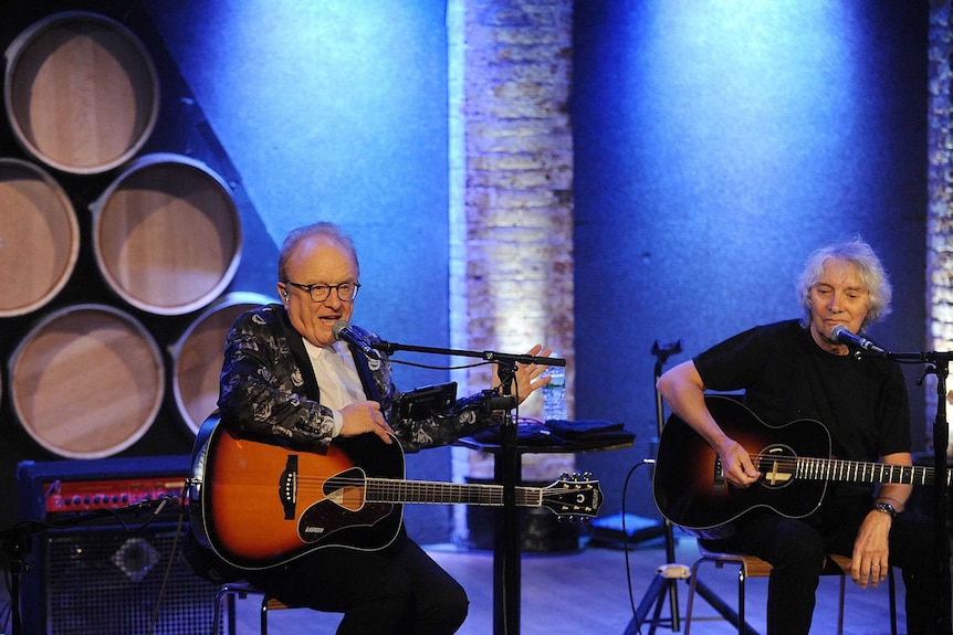 Musicians Peter Asher and Albert Lee performing on stage.