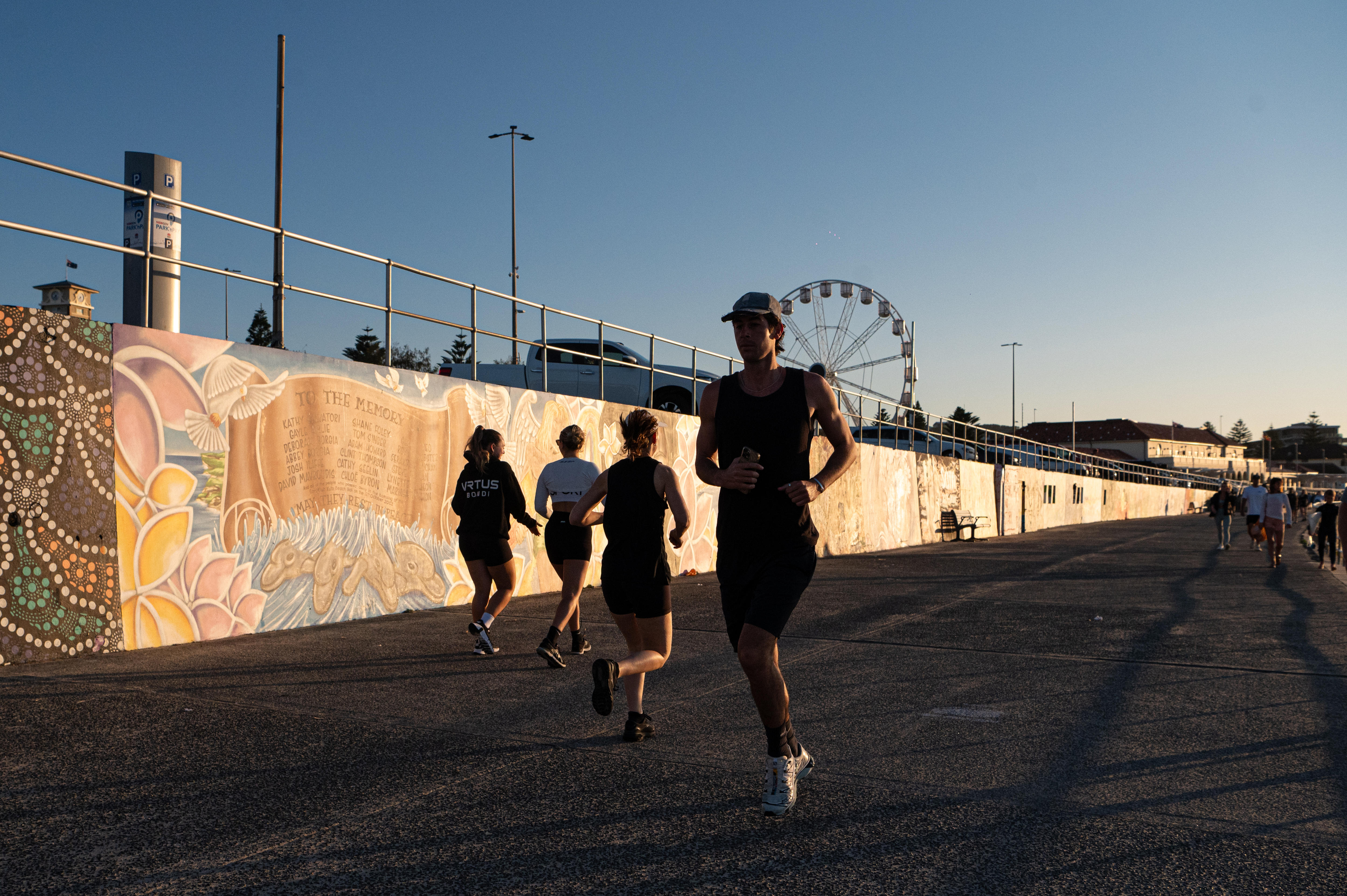 woman runs in shade on Sydney beach