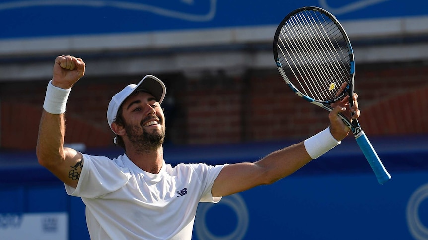 Australia's Jordan Thompson throws his hands in the air after winning.