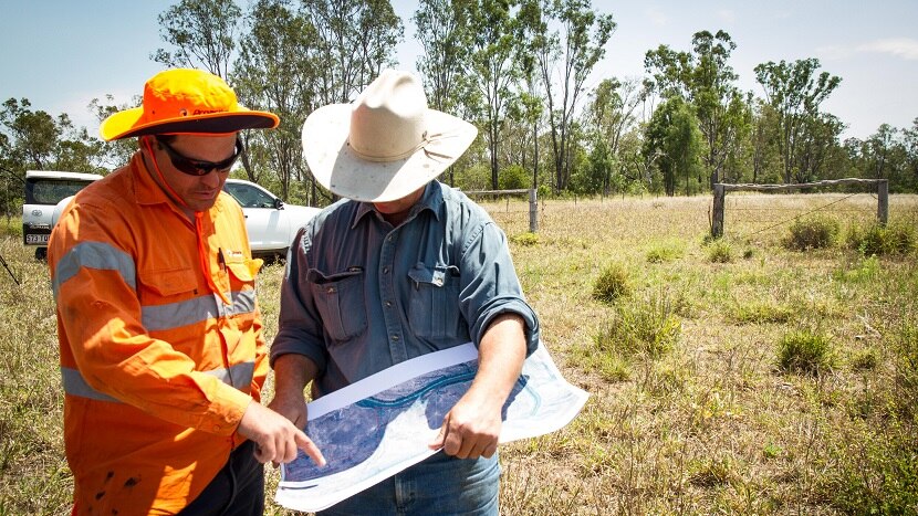 Property owner Andrew Lawrie looking over the soil drilling plans with the machinery worker.