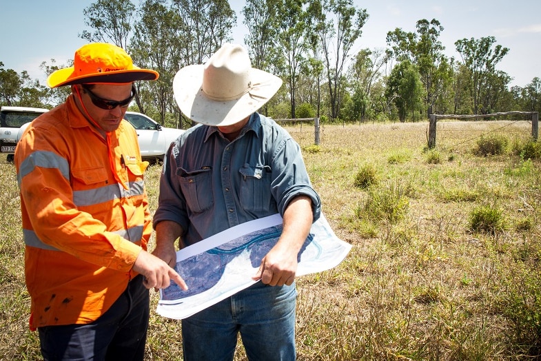 Property owner Andrew Lawrie looking over the soil drilling plans with the machinery worker.