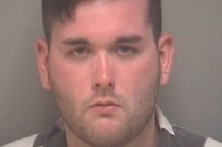 Police mug shot of dark-haired young man in black and white shirt.