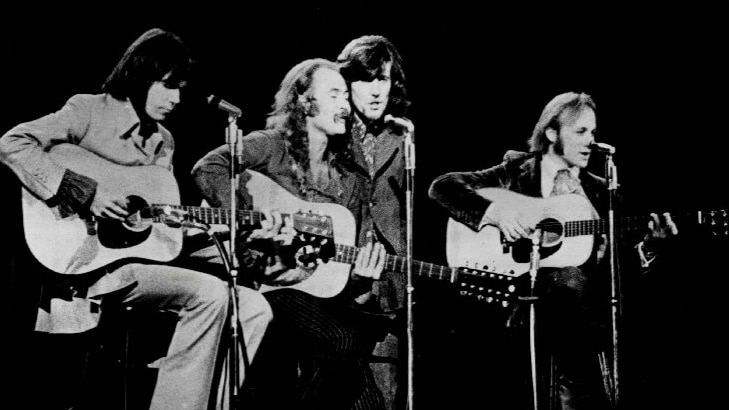 Black and white image of four musicians on stage.