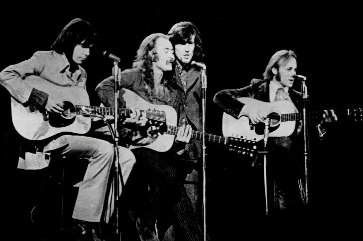 四位音乐家在舞台上的黑白照片。