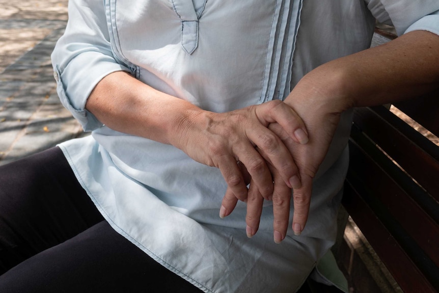 A close shot of a woman with her hands together.