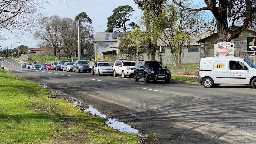 A line of cars on a road waiting to enter a coronavirus testing site at a football ground