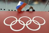 A fan holds the Russian flag over the Olympic rings during the Sochi Games.