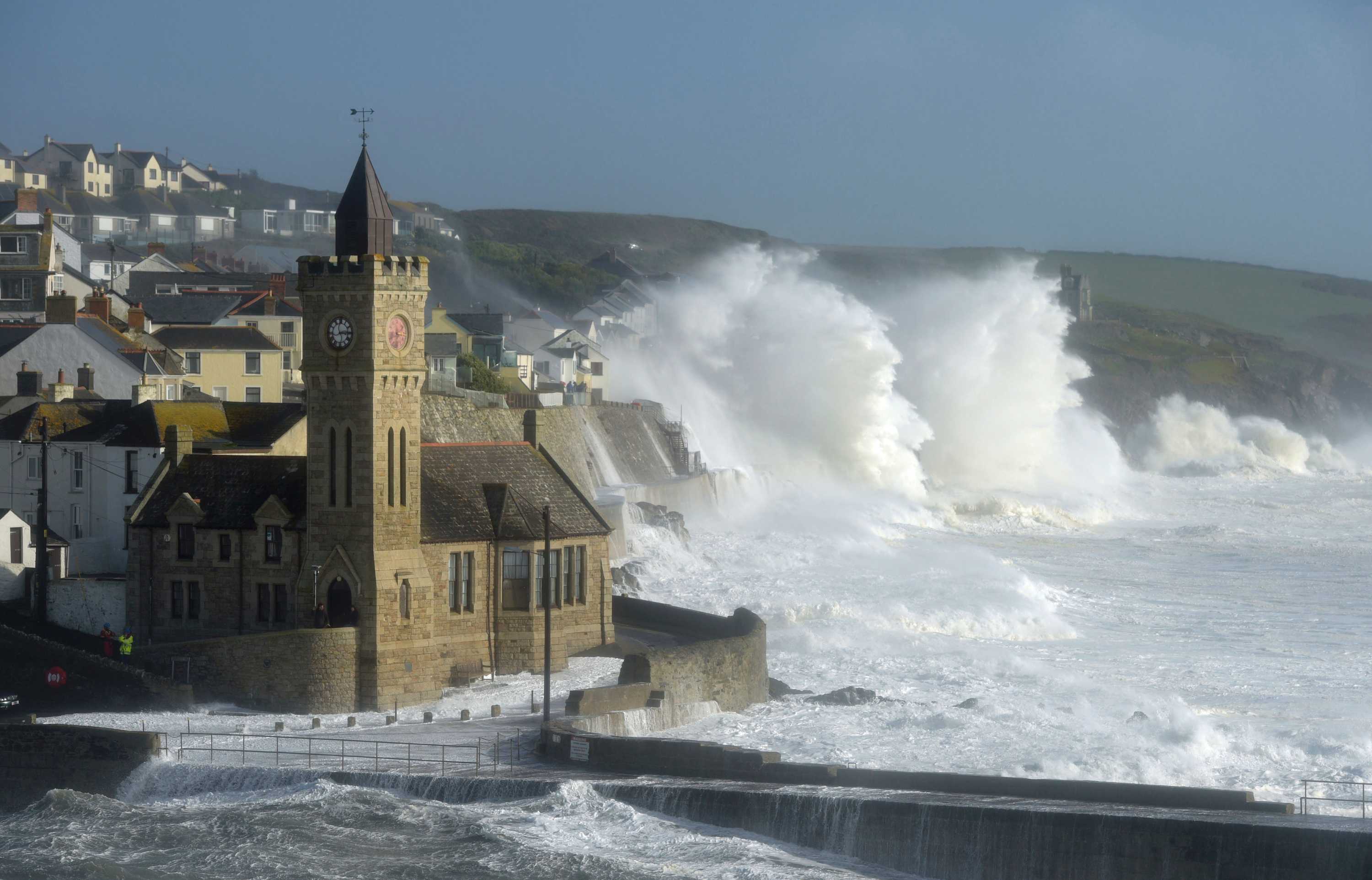 Waves break around the church in the harbour at Porthleven, Cornwall south-western England.