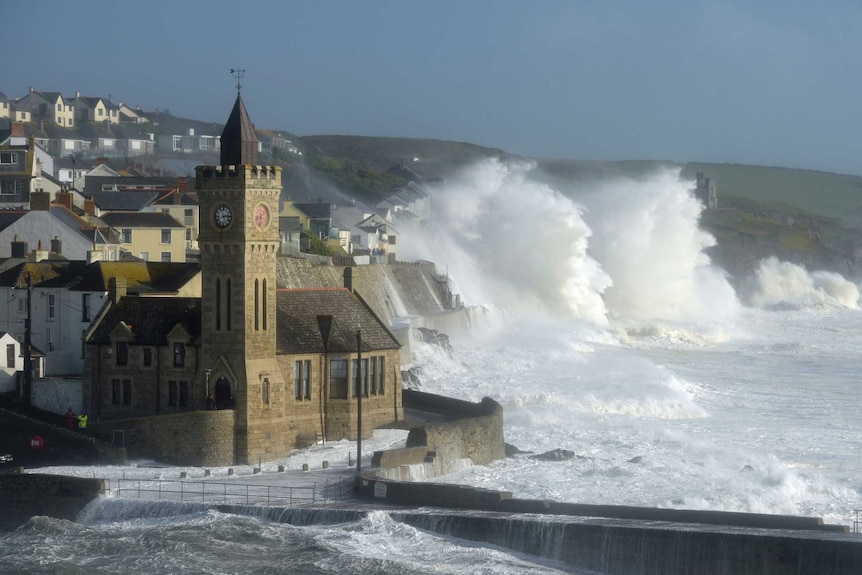 Waves break around the church in the harbour at Porthleven, Cornwall south-western England.