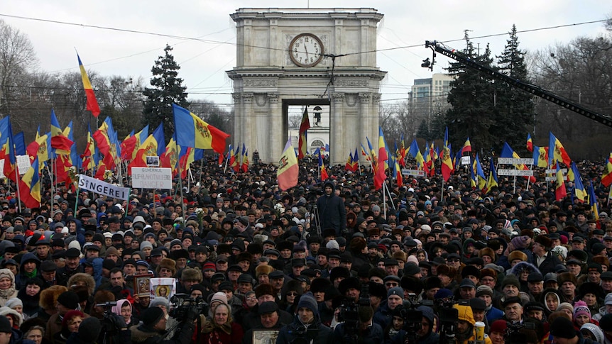 People attend a rally in front of the Parliament building in Chisinau.