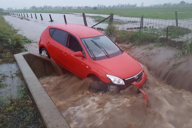 A red car in floodwaters