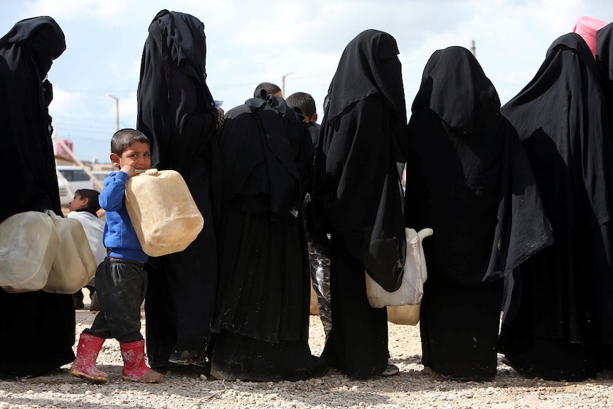 Women stand in a line with one little boy carring a fuel container