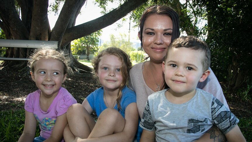 Photo of 27 year old mum Janelle with her three small children outside