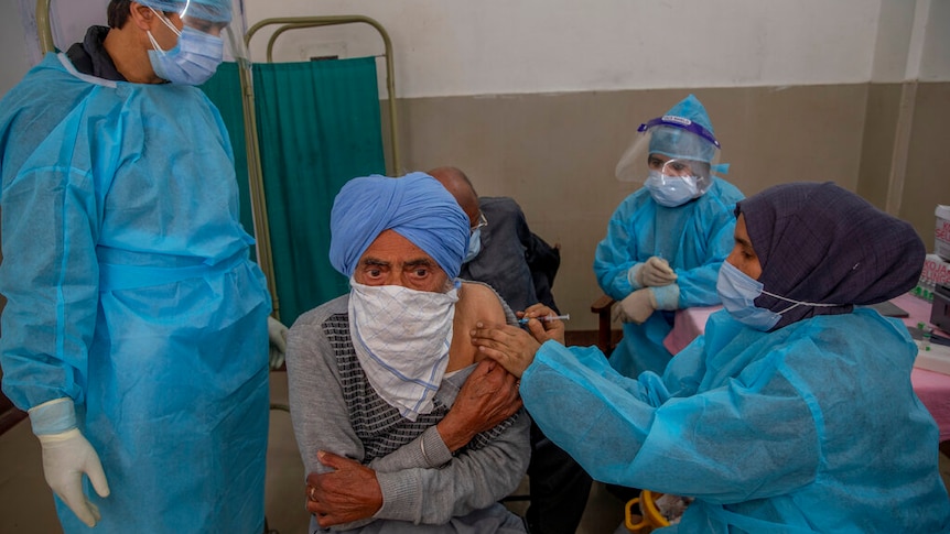 a man receives a vaccine for COVID-19 at a primary health center in Srinagar, Indian controlled Kashmir.