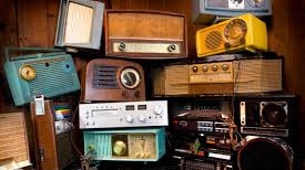 A large stack of vintage and retro radios