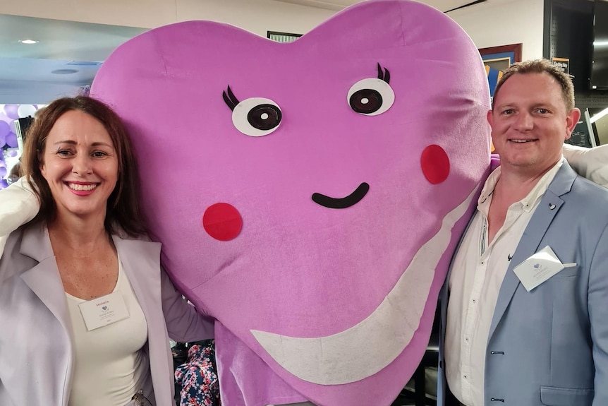 Ms Beattie and Mr Leishman with a person in a purple heart costume in between them.