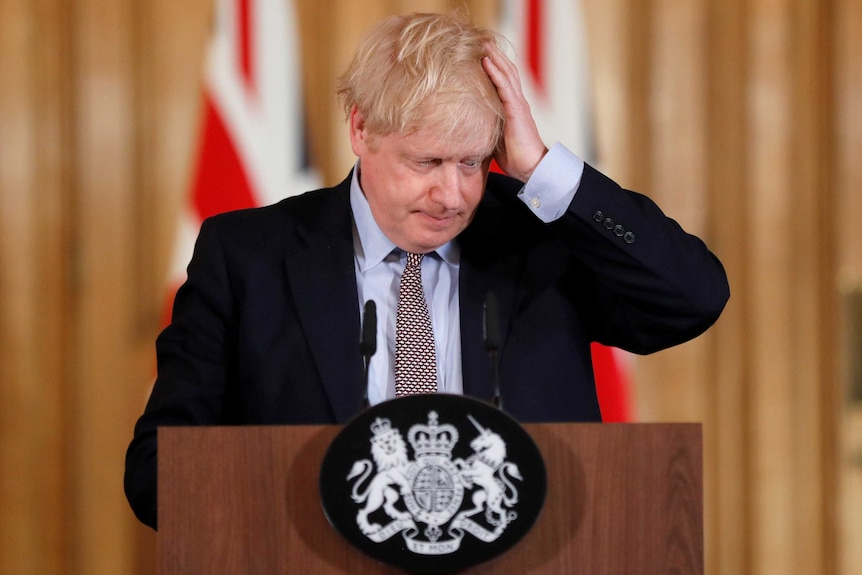 Boris Johnson ruffles his hair at a press conference