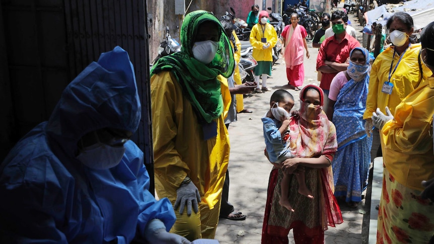 People wait to give their samples to medical staff at a slum area during India's lockdown.