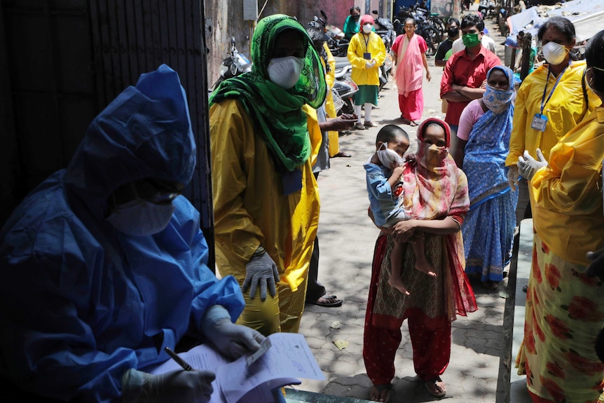 People wait to give their samples to medical staff at a slum area during India's lockdown.