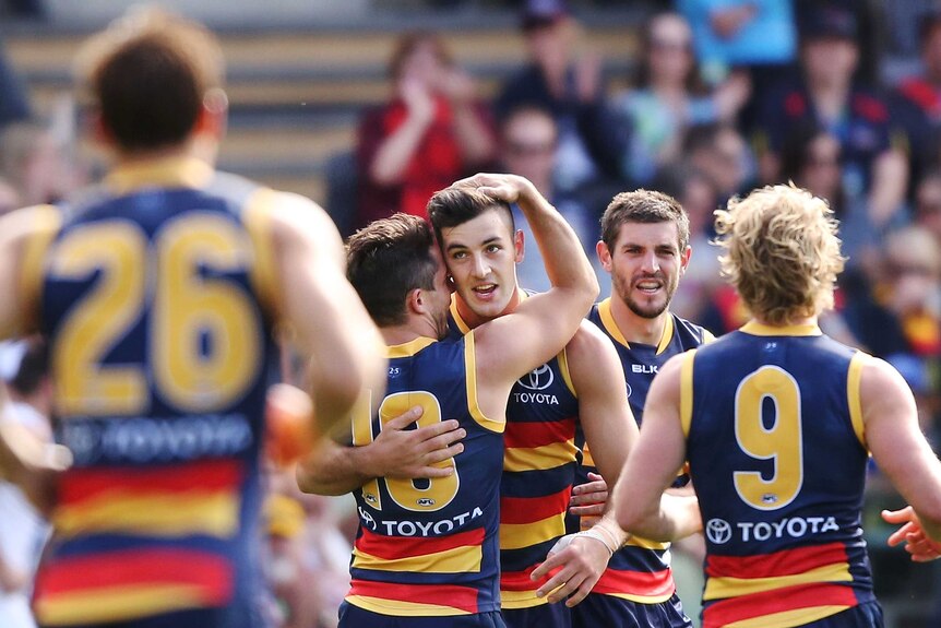 Taylor Walker is congratulated by his team-mates