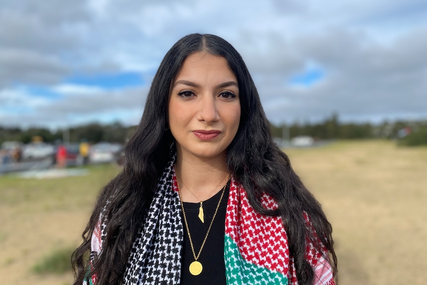 A woman wearing a palestinian garment around her shoulders