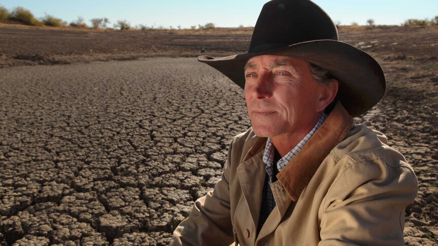 Cattle drover Brad Brazier inspects dry earth outside Moree.