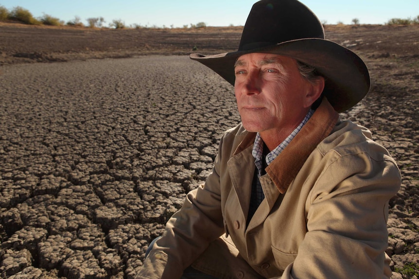 Cattle drover Brad Brazier inspects dry earth outside Moree.