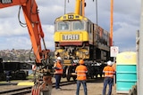The TasRail locomotive is lifted after derailing incident, Devonport