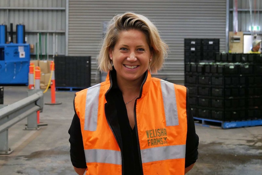 Catherine Velisha stands in the middle of a packing shed.