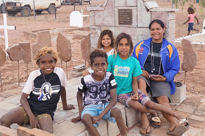 Selma Smiler, grandchild of Vincent Lingiari, with his extended family at his grave.