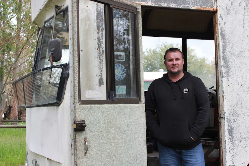 Andrew Hayden standing in the doorway of an old bus he plans to renovate.