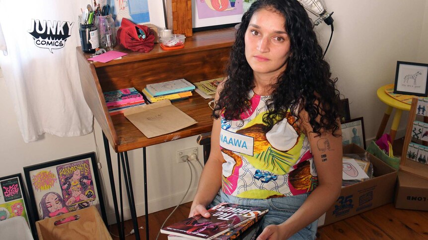 Vlada Edirippulige sits at home surrounded by stock from her now closed comic store.
