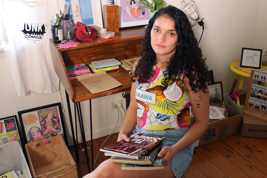Vlada Edirippulige sits at home surrounded by stock from her now closed comic store.