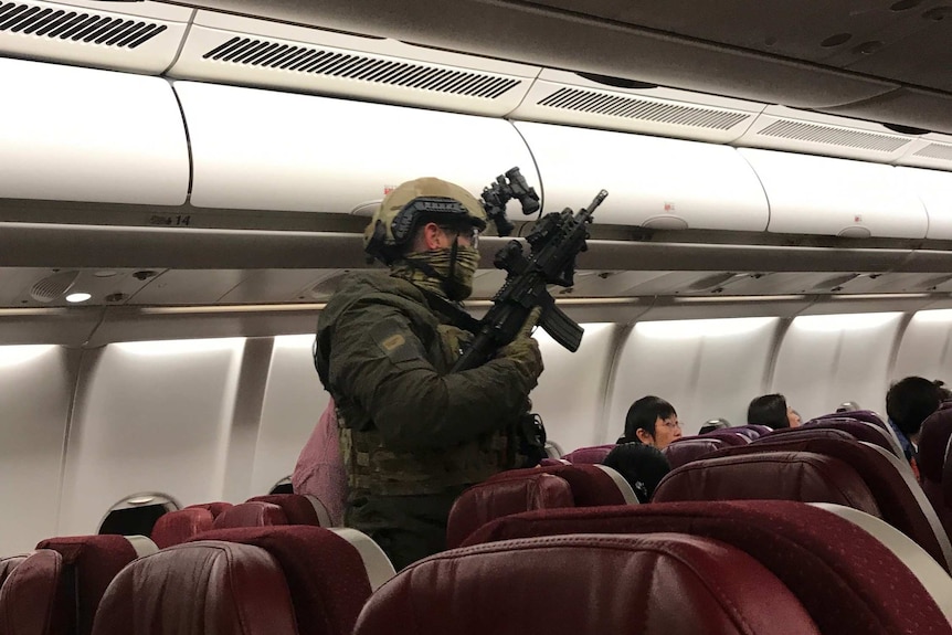 A heavily armed police officer is seen onboard a Malaysia Airlines plane.