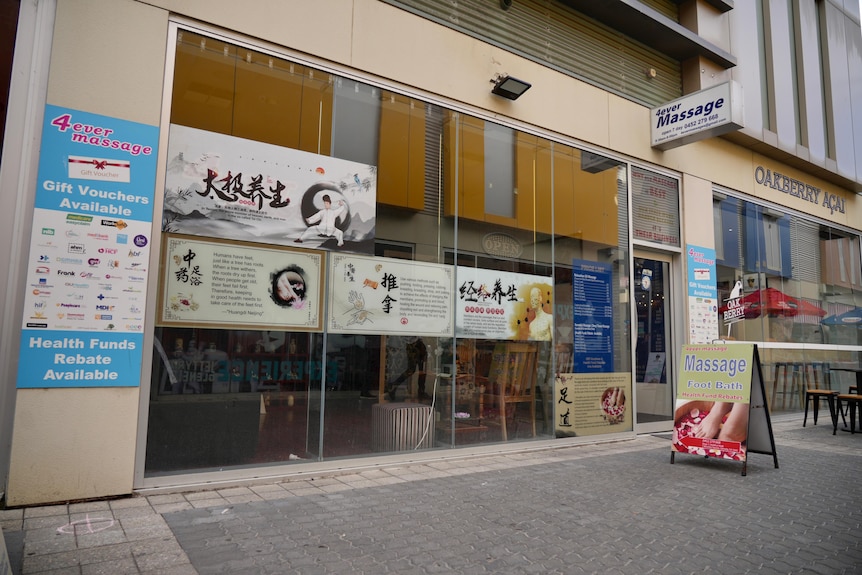 A massage parlour with signs of chinese words on its glass doors