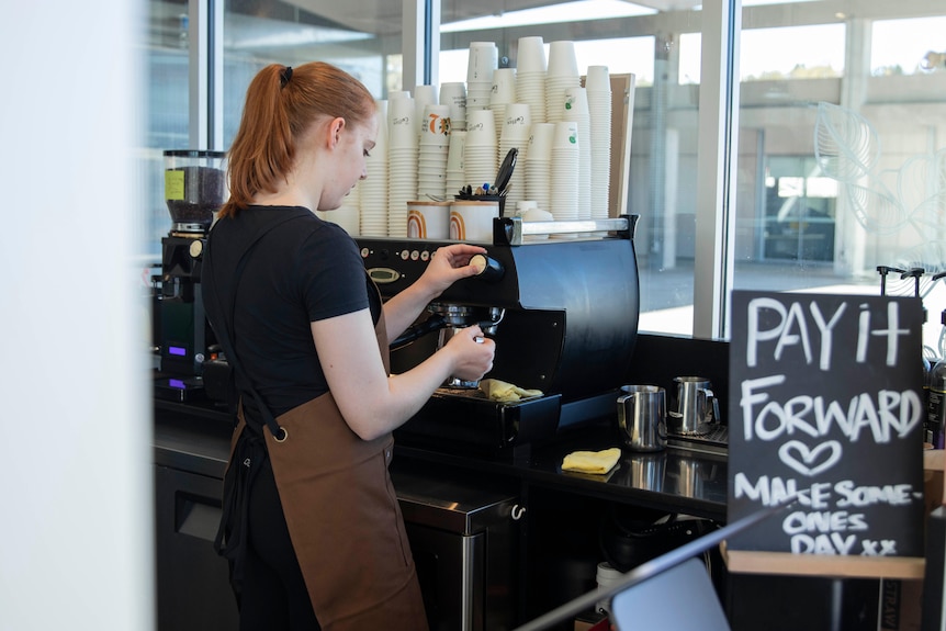 A woman making a coffee in a cafe
