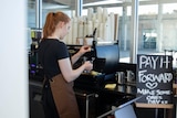 A woman making a coffee in a cafe