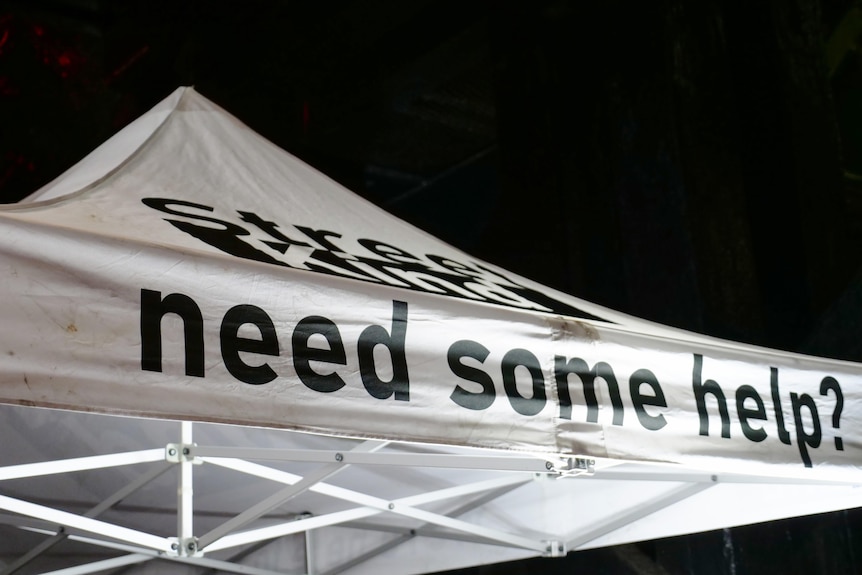 A pop-up white gazebo tent with black letters reading Street Kind, need some help?